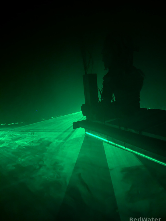 The silhouette of the dock troll is evident against the green glow of the laser swamp