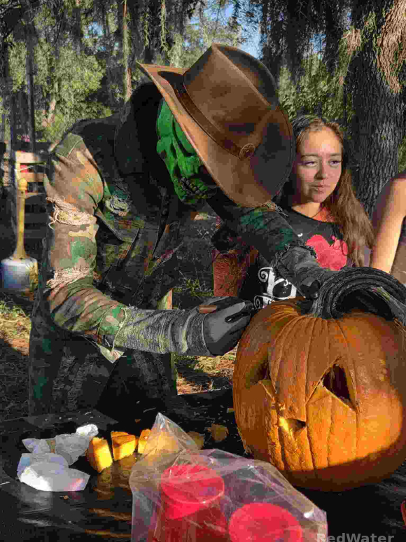 Gideon the Skeleton is seen concentrating on carving a pumpkin