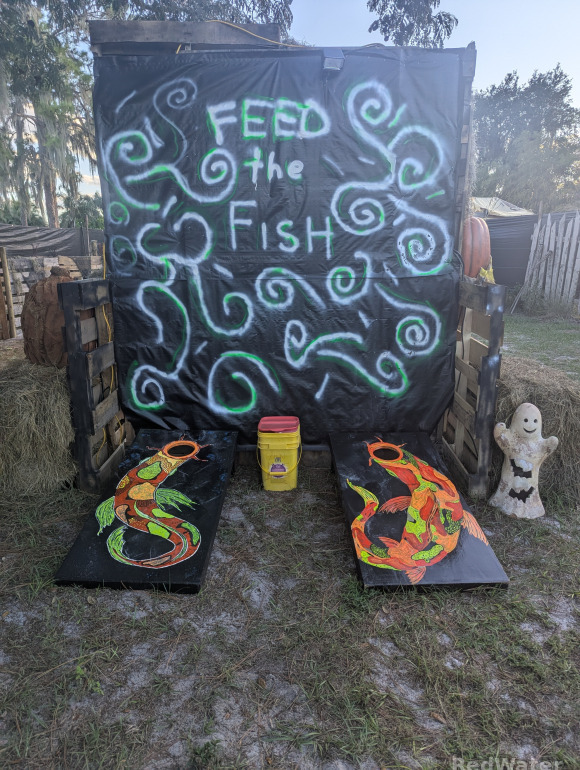 The same two corn hole boards decorated with koi fish during daylight hours